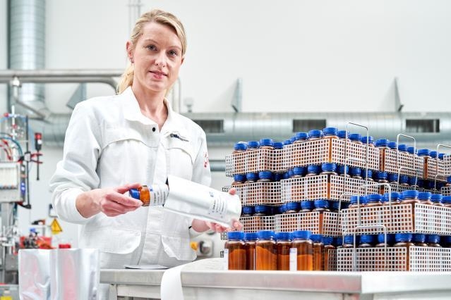 A JRC scientist holding in her hands a small bottle: infant formula reference material
