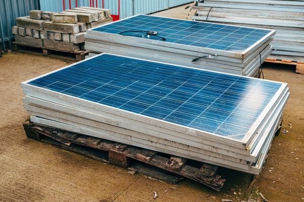 Old obsolete solar panels piled in a yard 